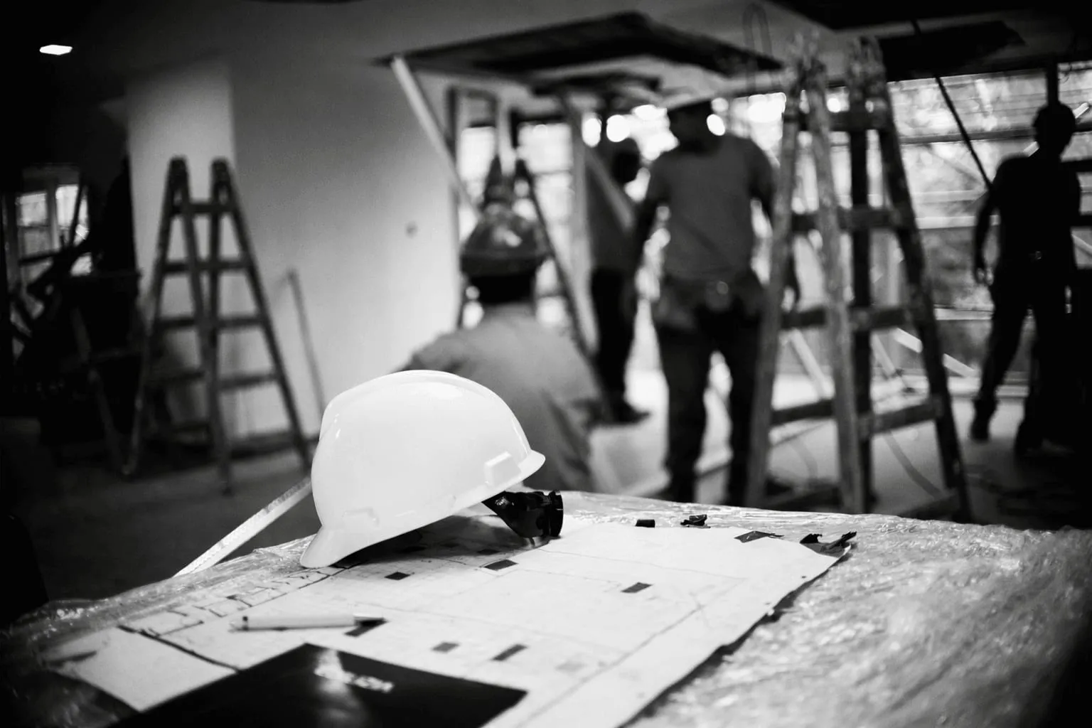 Casco de obra sobre planos de arquitectura en una construcción