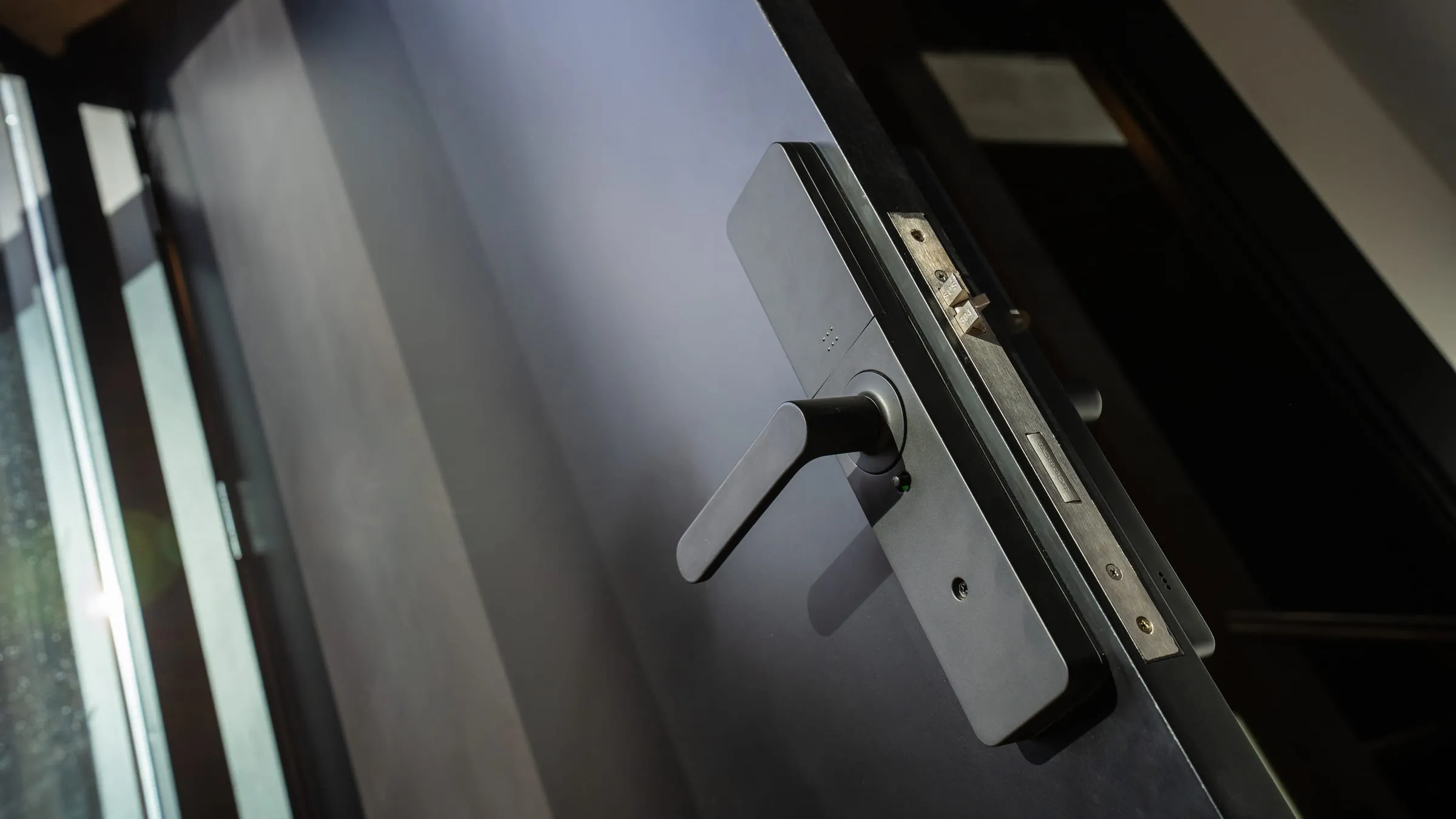 Detalle de cerradura de seguridad sobre puerta laqueada negra en Buena Vista Aldea Black