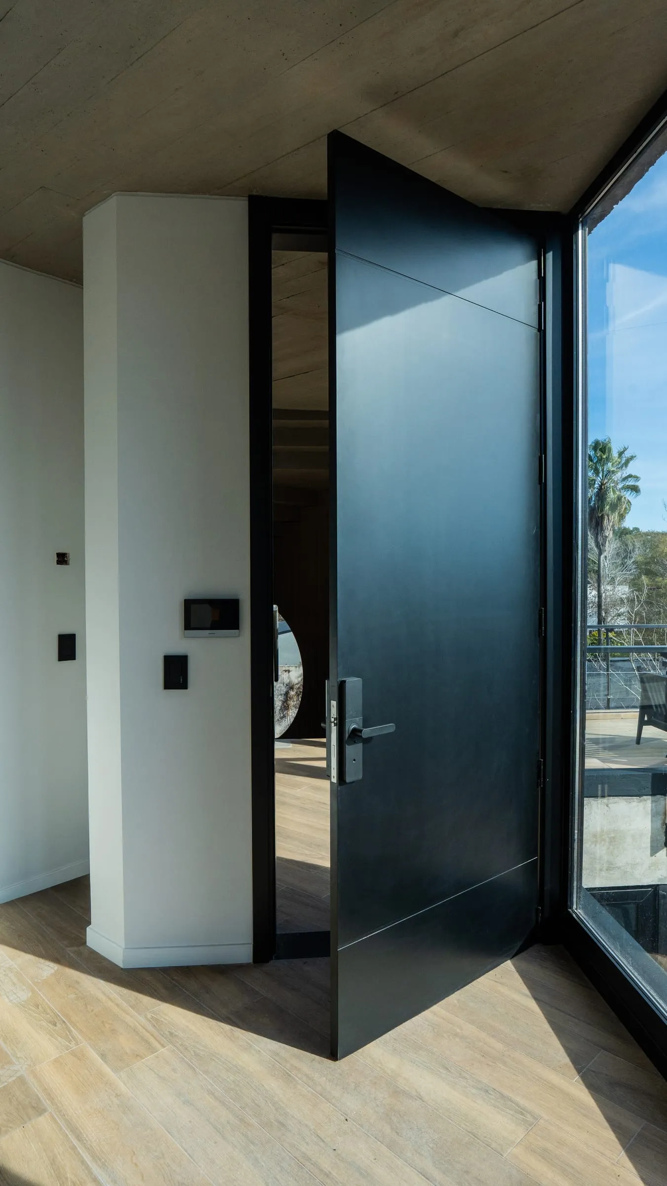 Puerta de ingreso negra de piso a techo abierta hacia la terraza en oficina de Buena Vista, Fisherton