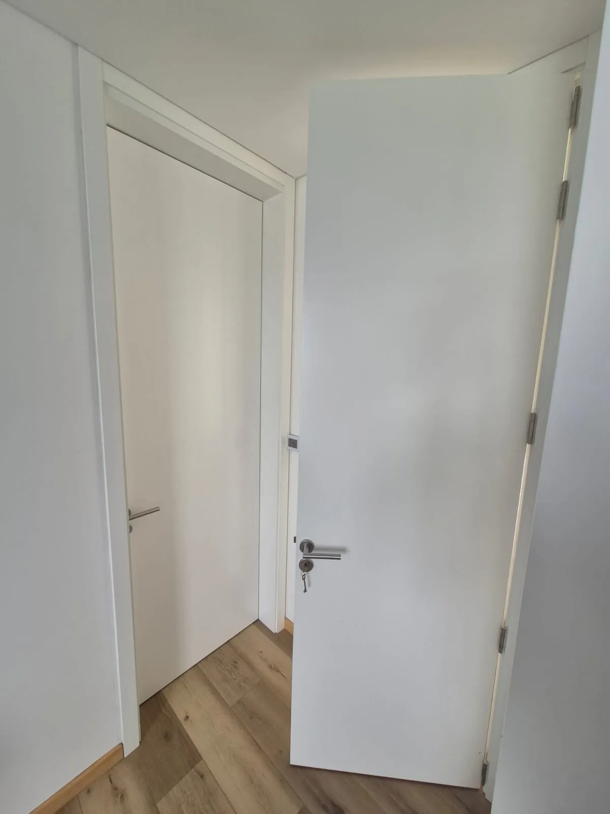 Puerta placa blanca abierta en pasillo de Casa Vida