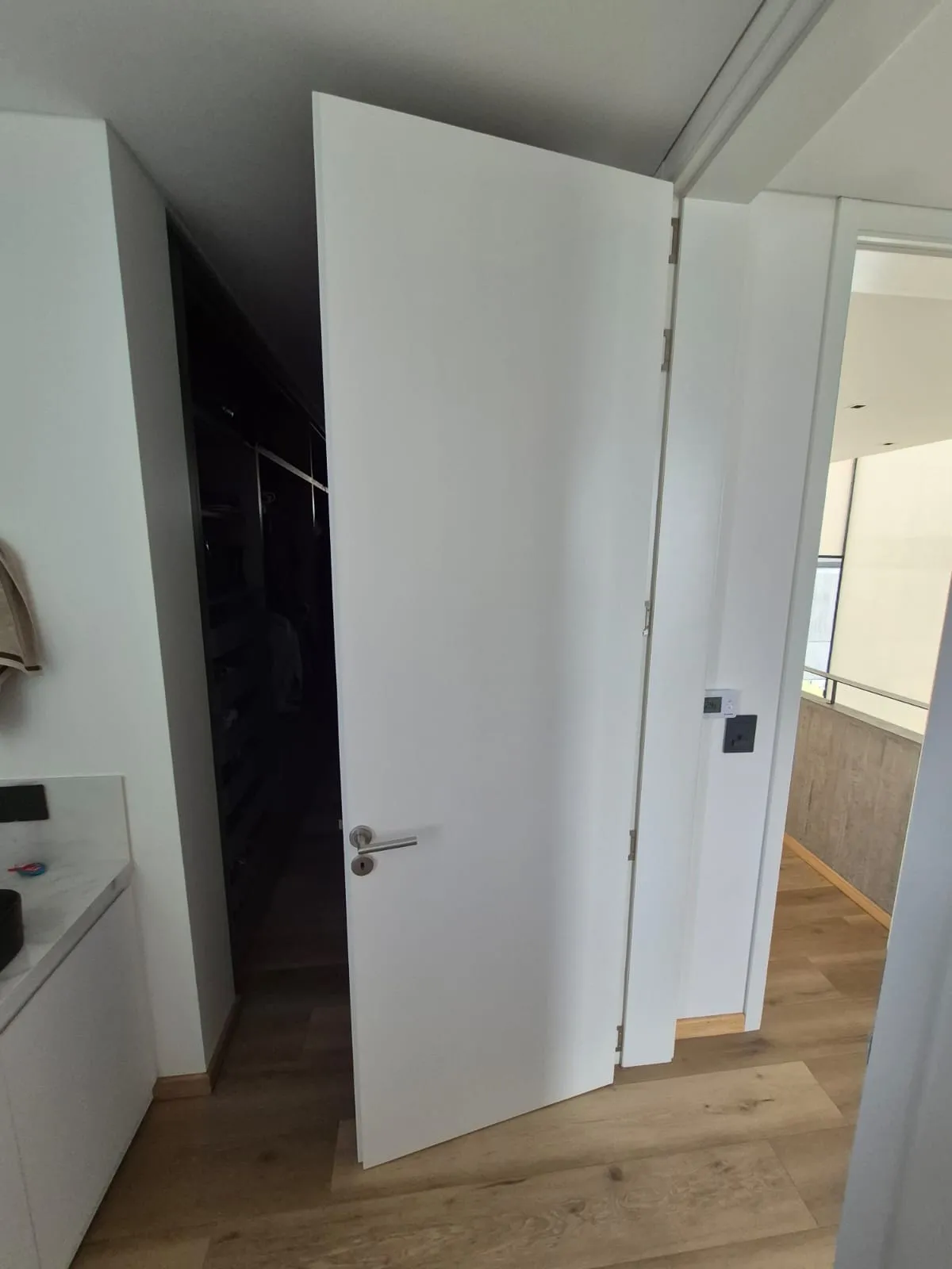 Puerta placa blanca abierta hacia vestidor en Casa Vida
