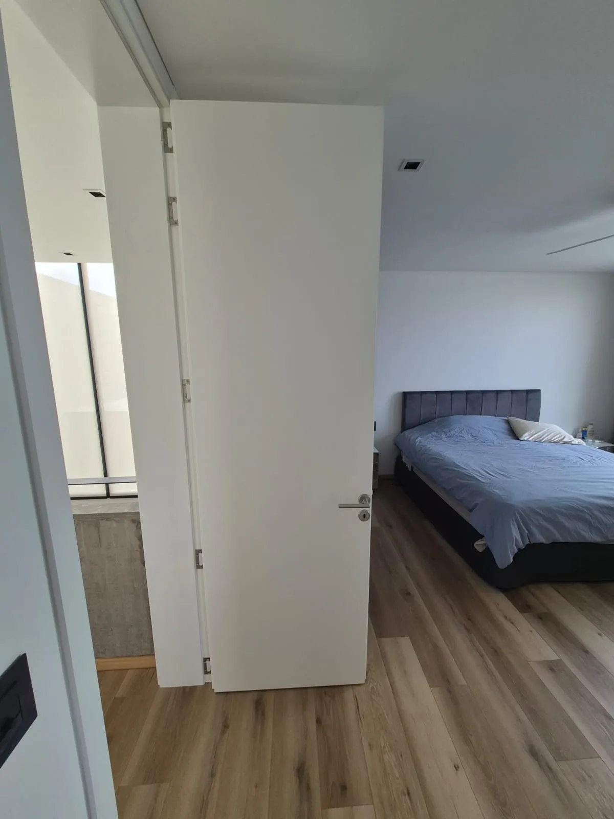 Puerta placa laqueada blanca integrada al diseño de Casa Vida