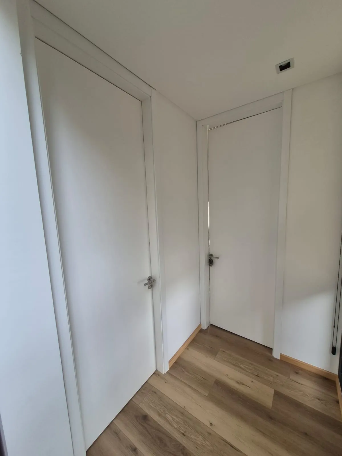 Puerta laqueada blanca con herrajes de acero en Casa Vida