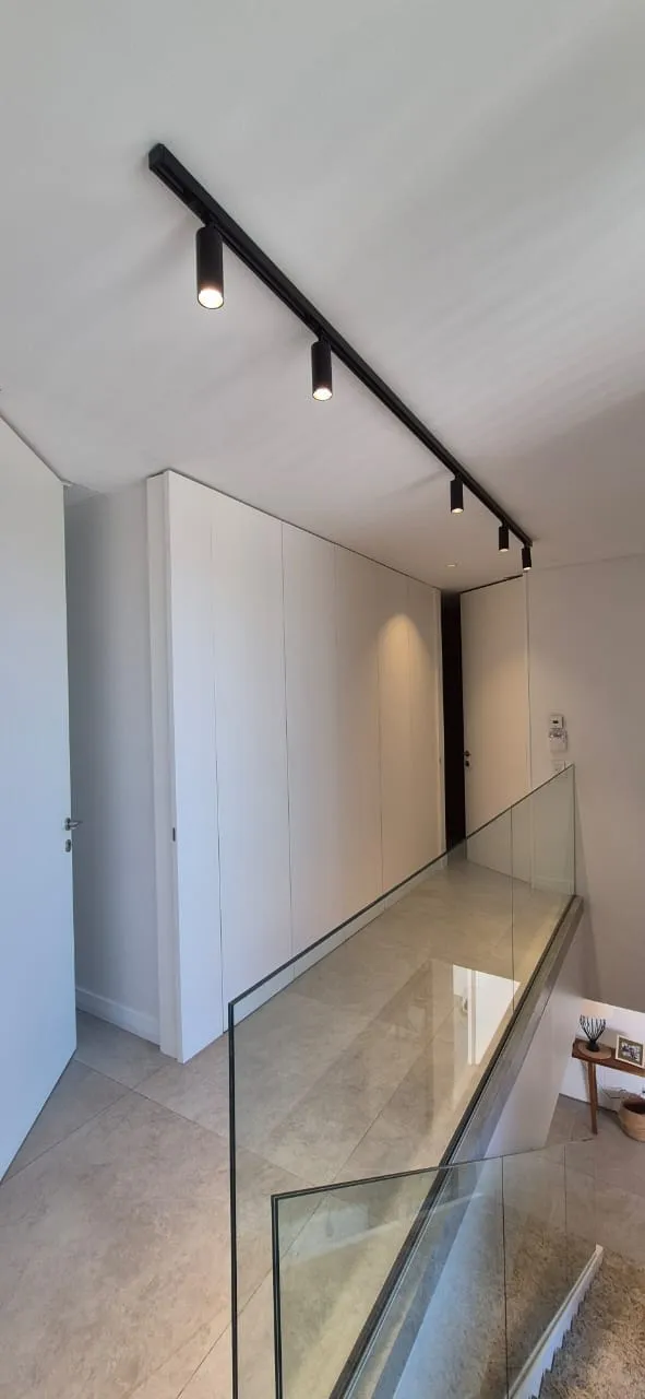 Frente de puertas filomuro blancas integradas a la pared en un entrepiso