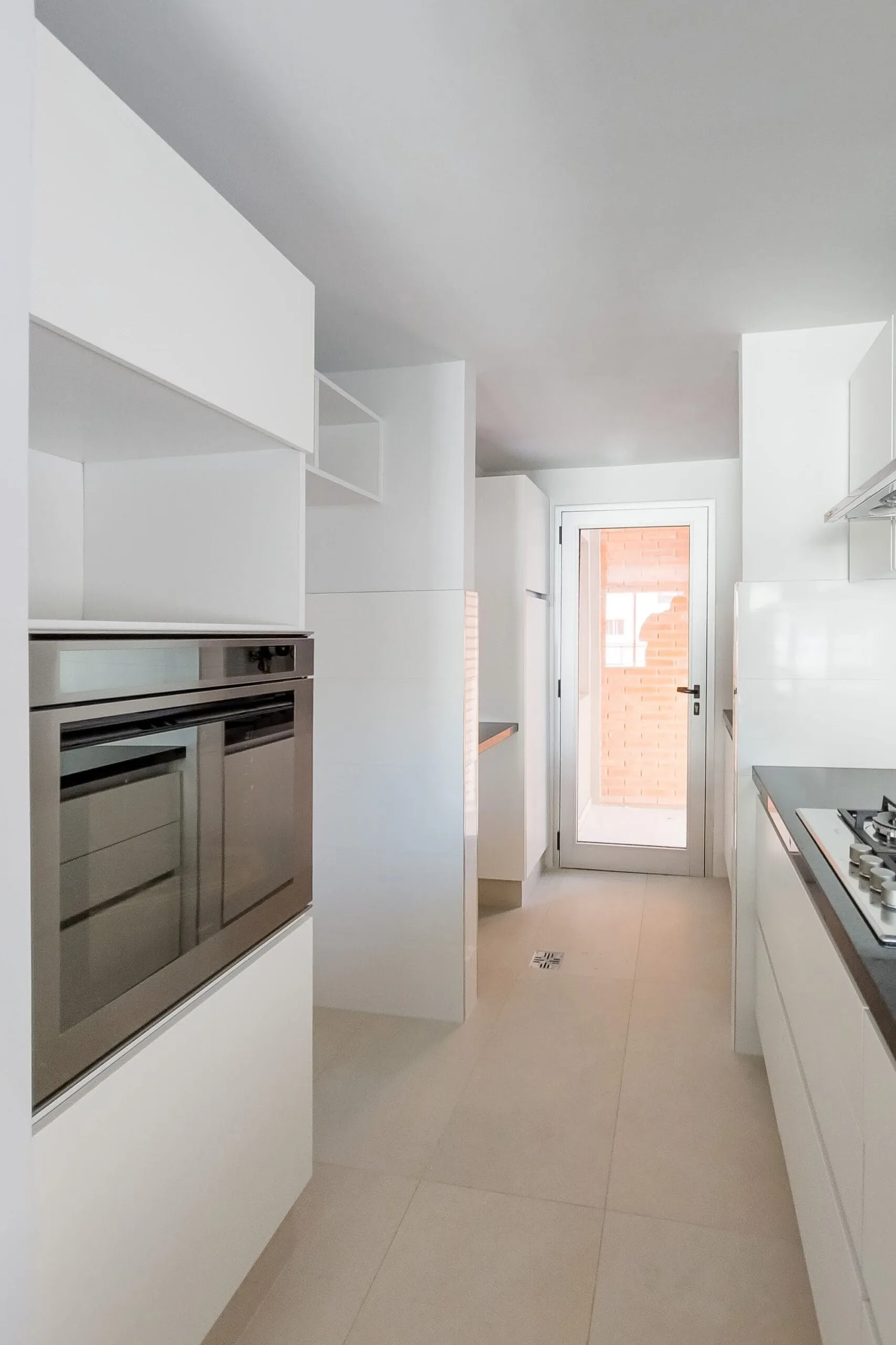 Cocina blanca con horno empotrado en unidad de Plaza España
