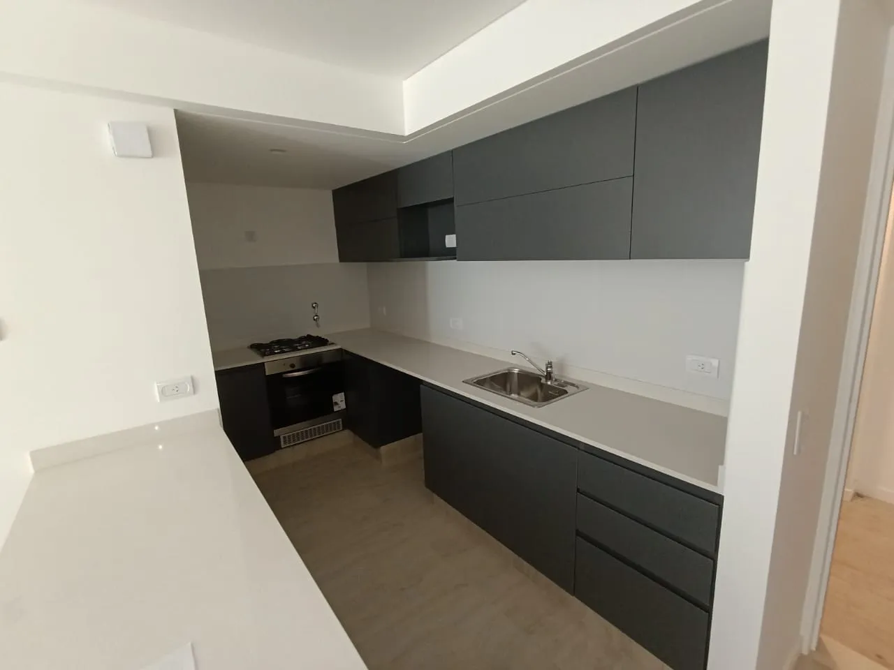 Cocina en melamina color con mesada blanca en unidad de Sol Patagonia